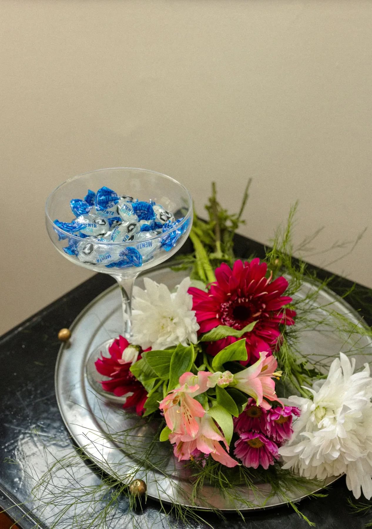 Copa reutilizada como florero con flores celestes