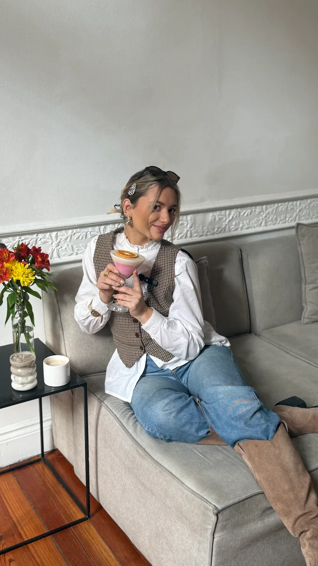 Agus, la creadora de Velumé, sentada en un sillón con una vela en copa.